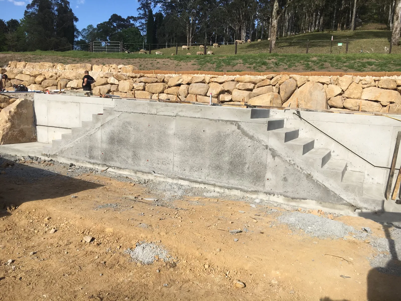 Concrete retaining structure and steps built into a sloping property