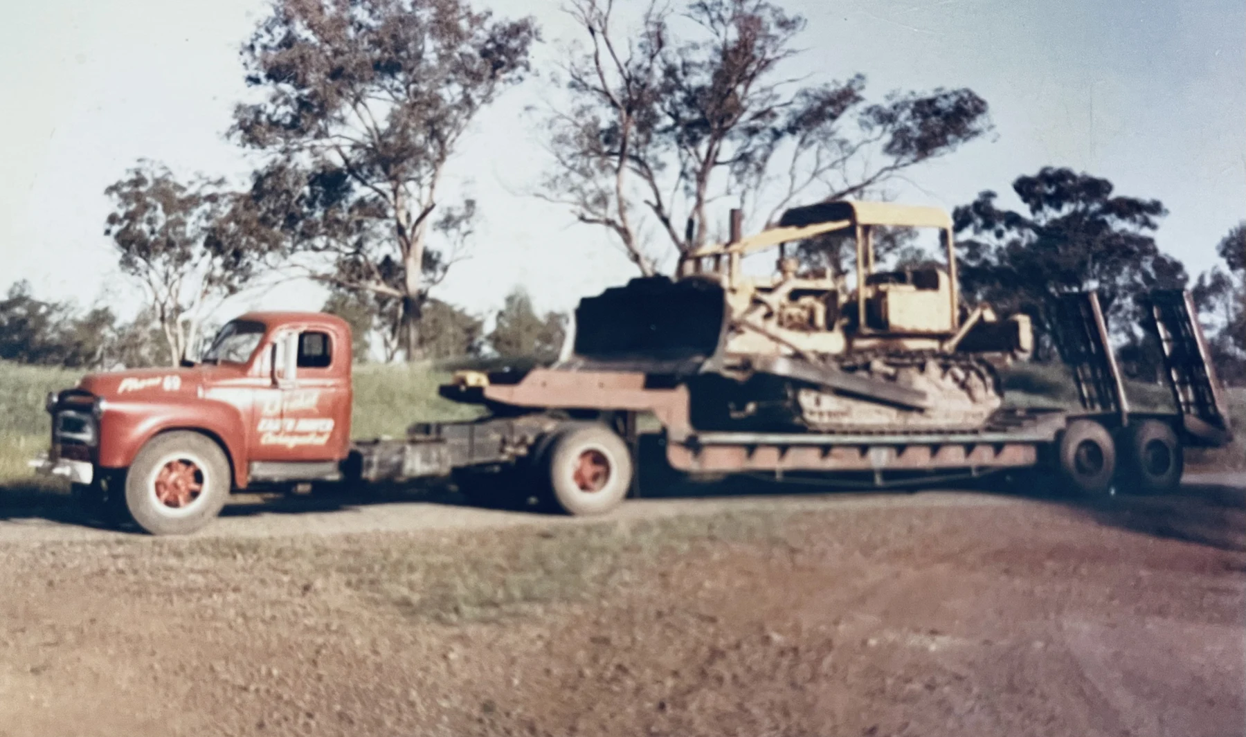 Historic photograph of a Huckel truck transporting earthmoving machinery