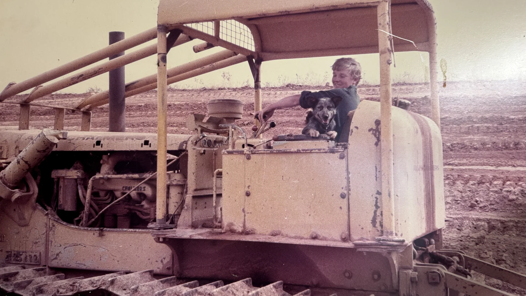 Historic crawler machinery with an operator and dog in the Huckel family archive