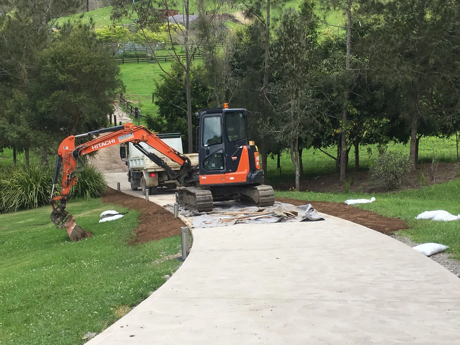 Huckel excavators completing earthworks beside a newly formed concrete driveway